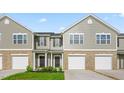 Townhome with gray siding, brick accents, garage, and a well-maintained lawn at 5560 Henley Ridge Dr # 187, Graham, NC 27253