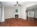 Bright living room featuring hardwood floors, a ceiling fan, and fireplace at 6016 Farm Gate Rd, Raleigh, NC 27606