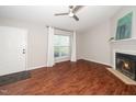 Cozy living room featuring a fireplace, ceiling fan and a large window at 6016 Farm Gate Rd, Raleigh, NC 27606