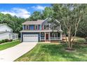 Charming two-story home with a blue exterior, red door, white trim, and a lush green lawn at 605 Catlin Rd, Cary, NC 27519