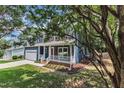 Charming two-story home with a blue exterior, red door, white trim, and a green lawn with mature trees at 605 Catlin Rd, Cary, NC 27519