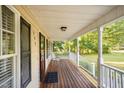 View of covered front porch with wood decking, white railing, and view of manicured front yard at 609 N Country Club Dr, Oxford, NC 27565