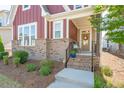 Inviting entrance with brick steps leading to a charming front porch and decorative wreath at 6612 Enrichment Ln, Raleigh, NC 27616