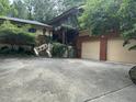 Home featuring a two-car garage, lush landscaping, and a charming stone staircase at 71010 Russell, Chapel Hill, NC 27517