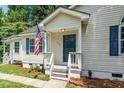 Inviting front entrance with a charming porch, American flag and well-kept landscaping at 725 E Maple Ln, Fuquay Varina, NC 27526