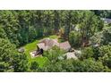 Aerial view of home nestled within lush trees, featuring a screened porch and spacious backyard at 9 Piney Grove Rd, Bahama, NC 27503