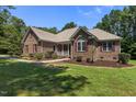 Inviting brick home with manicured lawn, red shutters, and a cozy covered front porch at 9 Piney Grove Rd, Bahama, NC 27503