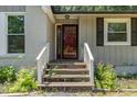 Home exterior featuring a red front door with white trim and a small porch with painted brick and siding at 908 Snow Hill Rd, Durham, NC 27712