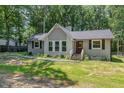 Charming single story home featuring a gray painted brick and siding exterior with a mature landscaped yard at 908 Snow Hill Rd, Durham, NC 27712