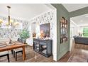 Elegant dining room with stylish wallpaper, hardwood floors, a modern light fixture, and sophisticated decor at 908 Woodland Grove Way, Wake Forest, NC 27587