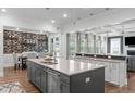 Gourmet kitchen with stainless steel appliances, gray island, and adjacent dining area at 909 Green Oaks Pkwy, Holly Springs, NC 27540