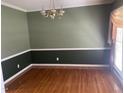 Empty dining room with wood floors, decorative molding, and chandelier, awaiting personal touches at 104 Belle Isle Ct, Cary, NC 27513