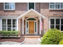 Inviting entryway with brick flooring, a solid wood door, sidelights, and neatly trimmed bushes at 105 Woodsage Way, Cary, NC 27518