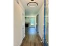 Inviting hallway featuring stylish lighting, wood floors, and view of the living room fireplace at 106 Viola Ln, Franklinton, NC 27525