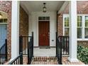 Close-up of the front door featuring a dark wood finish, house number, and covered porch at 111 Finsbury St, Durham, NC 27703