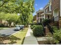 Pleasant street view showcasing the townhome community with sidewalks, street parking, and mature trees at 111 Finsbury St, Durham, NC 27703