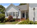 Inviting front entrance with well-kept landscaping, brick steps, and a view of the white siding home's windows at 113 Kelly Ln, Clayton, NC 27520