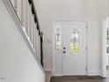 Elegant front door with decorative glass detailing, adjacent to a staircase with white railing at 1209 Waterford Green Dr Dr, Apex, NC 27502