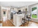 Bright kitchen featuring stainless steel appliances, white cabinetry and a breakfast bar with seating at 132 Ironwood Ln, Clayton, NC 27520