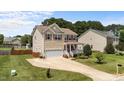 Inviting two-story home featuring a cozy front porch, lush lawn, and convenient two-car garage at 1713 Mclaurin Ln, Fuquay Varina, NC 27526