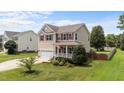 Charming home featuring a well-manicured lawn, complemented by vibrant plants and a welcoming front porch at 1713 Mclaurin Ln, Fuquay Varina, NC 27526