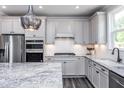 Modern kitchen features stainless appliances, subway tile backsplash, granite counters, and updated fixtures at 189 Churchill Way, Clayton, NC 27520