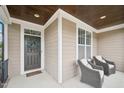 Inviting front porch features seating and a beautifully decorated front door at 1985 Firenza Dr, Apex, NC 27502