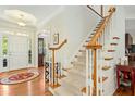 Elegant foyer featuring hardwood floors, a staircase, and decorative lighting at 203 Pathwood Ln, Durham, NC 27705