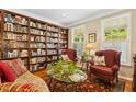 Cozy library with built-in bookshelves, comfortable seating, and ample natural light from bright windows at 203 Pathwood Ln, Durham, NC 27705