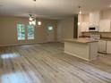 Open kitchen with island, white cabinets, granite countertops, and stainless steel appliances at 206 E Silver Belle Dr, Zebulon, NC 27597