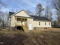 View of back exterior with a wooden deck and stairs leading to the yard at 206 E Silver Belle Dr, Zebulon, NC 27597