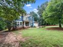 Two-story home featuring blue and beige siding, well-manicured lawn, and mature trees at 218 Inwood Forest Dr, Raleigh, NC 27603