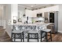 Modern kitchen featuring white cabinets, stainless steel appliances, and a stylish island with seating at 2413 Whelen Dr, Graham, NC 27253
