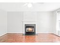 Cozy living room featuring hardwood floors and a charming fireplace with decorative mantle at 2419 Pepperstone Dr, Graham, NC 27253