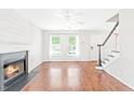 Bright living room features hardwood floors, a fireplace, and large windows offering plenty of natural light at 2419 Pepperstone Dr, Graham, NC 27253