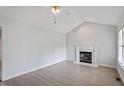 Bright living room with vaulted ceiling, fireplace, and light wood floors at 2474 Sumter Dr, Garner, NC 27529
