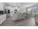 Bright kitchen with white cabinets, granite countertops, stainless steel appliances, island, and adjacent dining area at 31 Sweet Birch Ave, Zebulon, NC 27597