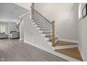 Elegant staircase featuring wood treads, white risers, and a stylish black iron railing, with open floor plan at 31 Sweet Birch Ave, Zebulon, NC 27597