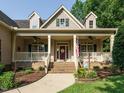 Inviting front porch with a brick entryway, decorative columns, and cozy seating at 334 Dell Meadows Pl, Four Oaks, NC 27524