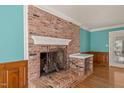 Close up of the brick fireplace with wooden mantle and ornate metal screen at 3821 Whispering Branch Rd, Raleigh, NC 27613