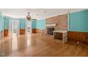 Bright living room features a brick fireplace, wood floors and a ceiling fan at 3821 Whispering Branch Rd, Raleigh, NC 27613