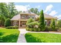 Stunning stone home with lush landscaping, a winding walkway, and a manicured lawn in a suburban setting at 401 Westbury Dr, Chapel Hill, NC 27516