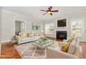 Bright living room with fireplace, plush rug, and stylish white couches with gold accents at 410 Stranraer Ct, Fuquay Varina, NC 27526