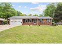 Charming brick home featuring a metal roof and well-manicured lawn at 410 W Tenth St, Siler City, NC 27344