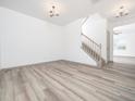 Bright living room featuring beautiful wood-look floors and a staircase at 425 Sunny Field Dr., Wake Forest, NC 27587