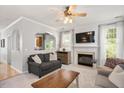 Cozy living room with a fireplace, large windows with natural light, and an archway leading to the kitchen at 4524 Drewbridge Way, Raleigh, NC 27604