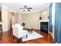 Cozy living room with fireplace, ceiling fan, hardwood floors, and ample natural light at 4732 Altha St, Raleigh, NC 27606
