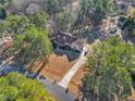 Expansive aerial view of a charming home nestled among lush trees with a long driveway and firepit at 506 Tirzah Dr, Lillington, NC 27546