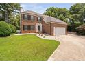 Charming two-story brick home features a manicured lawn and paved driveway at 5125 Pinehall Wynd, Raleigh, NC 27604