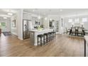 Open-concept kitchen with island, stainless appliances, pendant lighting and hardwood floors at 521 Olivia Crossing Ct # 19, Four Oaks, NC 27524